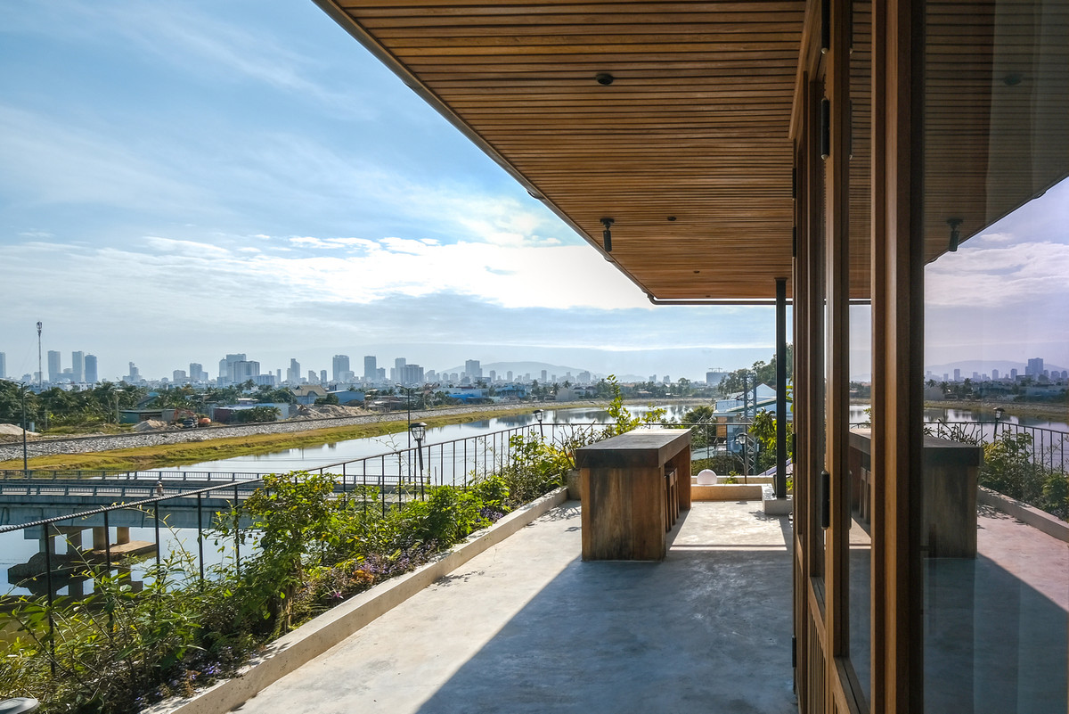 Sân hiên nhìn ra dòng sông thơ mộng, xa xa là thành phố nhấp nhô yên bình trong sương sớm.