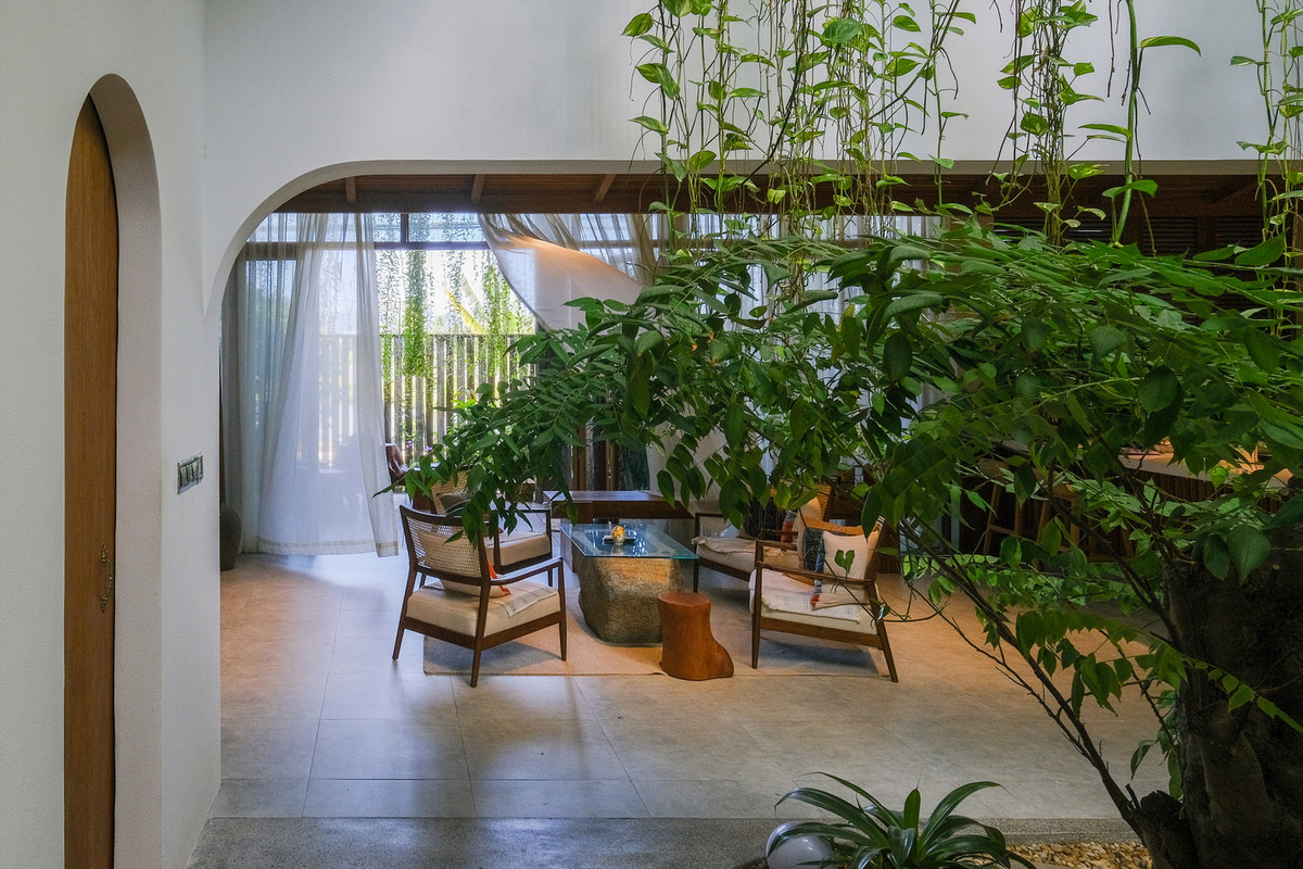 Không gian tiếp khách dưới mái hiên mở ra hai khu vườn tươi tốt.