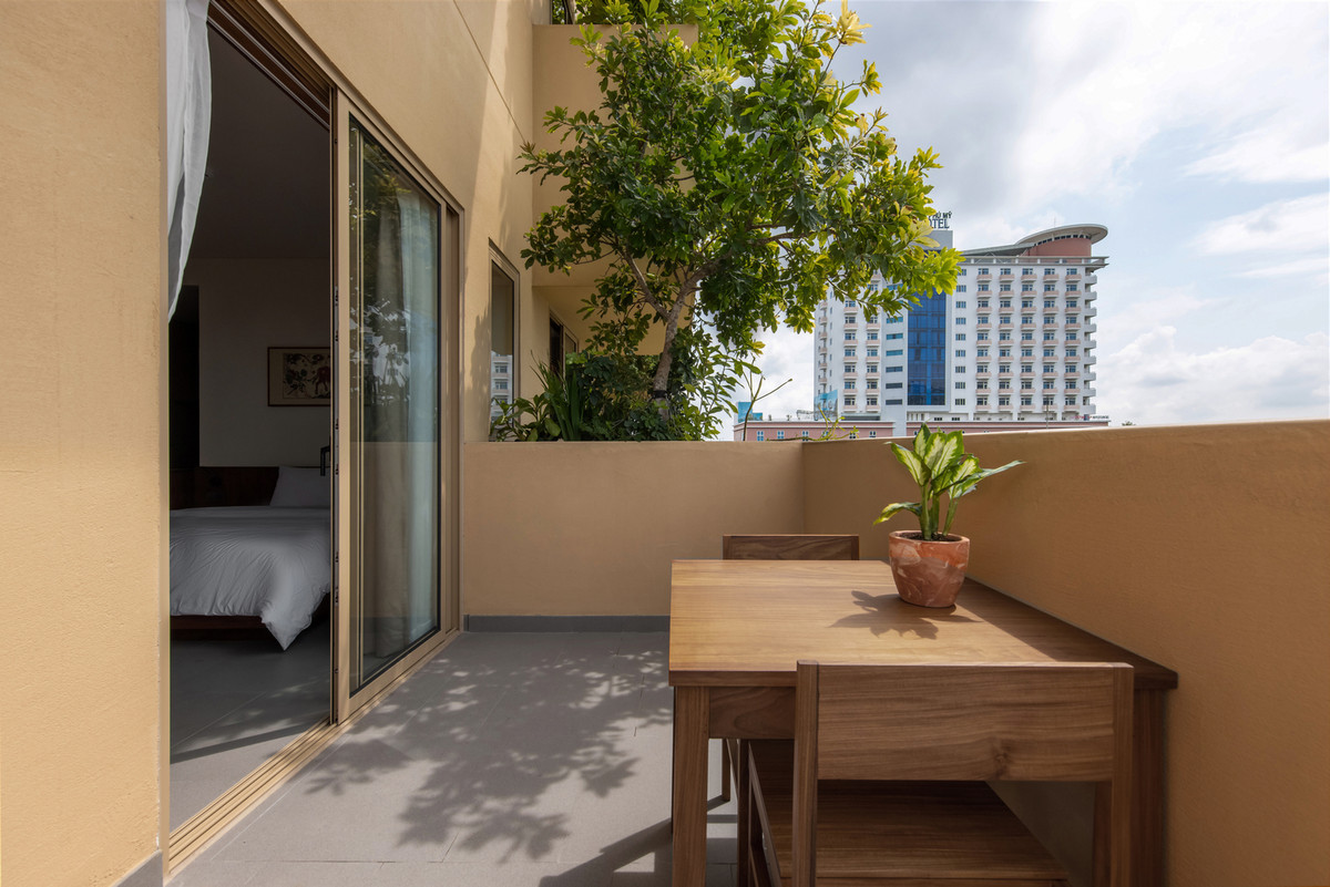 Từ phòng ngủ có thể nhìn ra khoảng ban công xanh nhờ hệ cửa kính lớn.