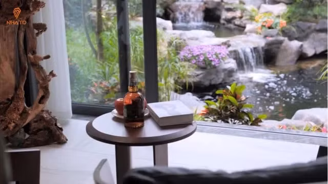 Phòng khách không chỉ rộng mà còn thoáng đãng nhờ hệ thống cửa kính đón ánh sáng được thiết kế theo dạng cửa trượt, lưu thông không khí với khu vực sân vườn bên ngoài. Ảnh chụp màn hình