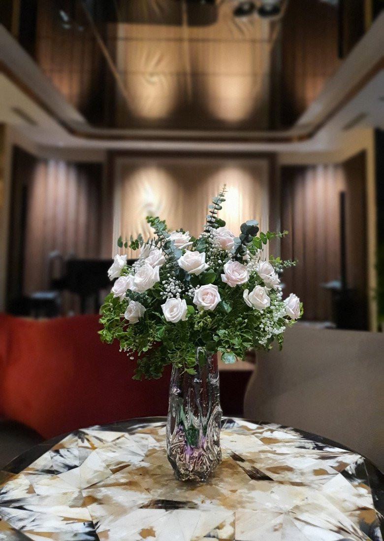 Hoa cắm trong bình pha lê làm bừng sáng cả góc nhà.