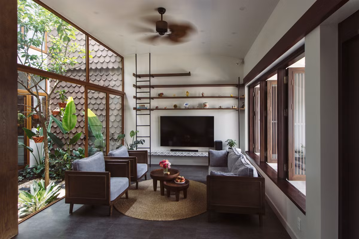 Phòng khách bố trí một bộ bàn trà, ghế ngồi bằng gỗ, kết hợp với đệm mềm bằng vải.