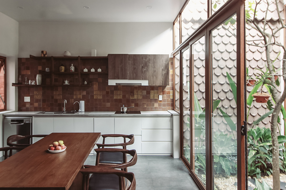 Ngăn cách giữa sân trong và phòng khách là hệ cửa kính trượt.