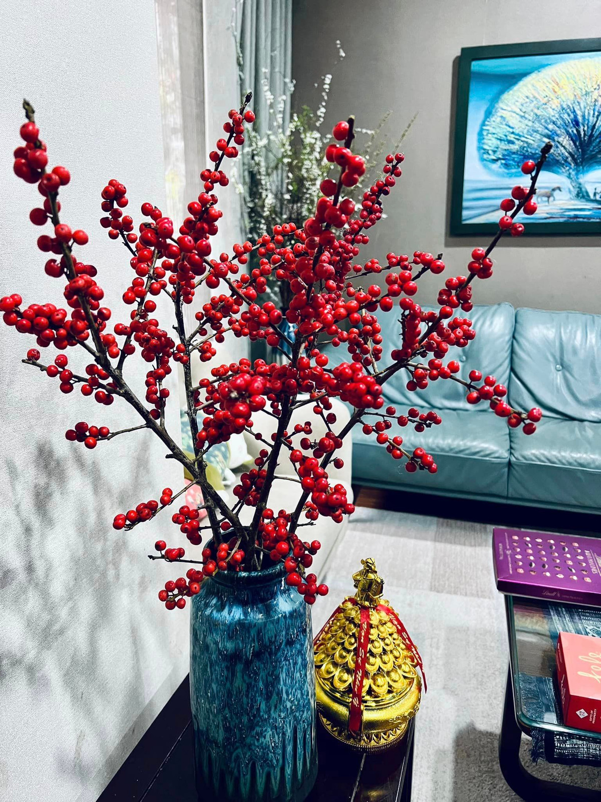 Trong phòng khách, Diễm Quỳnh đặt một bình đào đông đỏ.