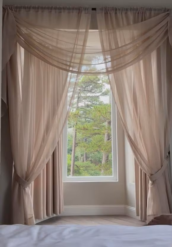 Phòng ngủ có cửa sổ nhìn thẳng ra rừng cây xanh mướt.