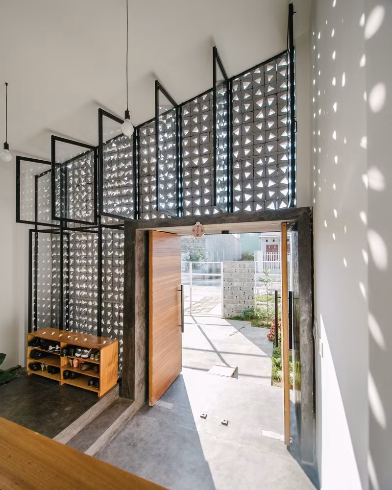 Mặt tiền gồm 2 lớp, lớp ngoài là bức tường gạch lỗ và lớp trong là cửa kính khung thép.