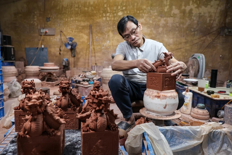 Gần Tết Nguyên đán Giáp Thìn 2024, các xưởng gốm làng Bát Tràng (Gia Lâm, Hà Nội) tất bật "trình làng" nhiều vật phẩm rồng độc đáo. Trong đó, linh vật rồng dát vàng được nhiều khách hàng ưa chuộng. Ảnh: Vietnam+