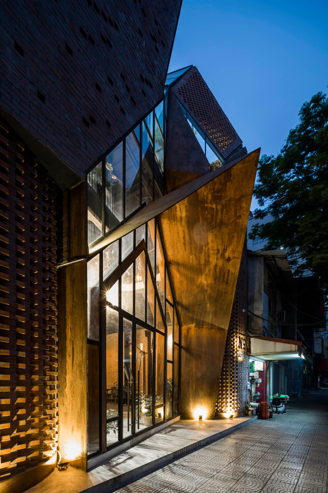 Bên cạnh sắt rỉ, kính và gạch được sử dụng hợp lý giúp quán cà phê nổi bật giữa khu phố khi đêm về.