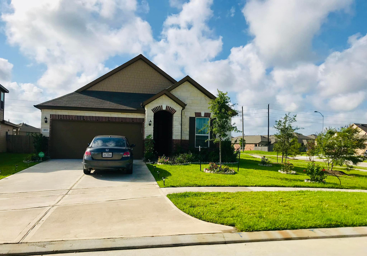 Phía trước nhà là khoảng sân rộng rãi với thảm cỏ xanh mướt.