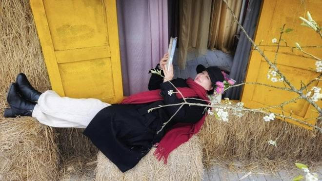 Nghệ sĩ Chiều Xuân từng đến nhà tranh của Tú Oanh, thích thú nằm lên những đụn rơm bên khung cửa sổ sắc màu, ngắm nhìn hoa cỏ. Nguồn ảnh: FBNV