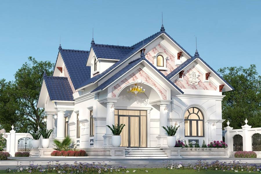 Nhà cấp 4 mái Thái 2 mặt tiền sử dụng tông màu trắng sang trọng. Xung quanh là sân vườn với cỏ xanh, cây cối và hoa rực rỡ. Ảnh: Lg