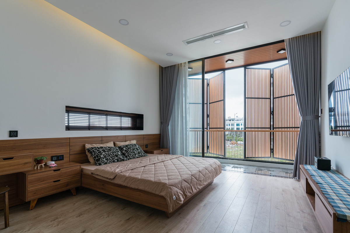 Phòng ngủ trên tầng 2 và phòng đọc sách trên tầng 3 lấy ánh sáng tự nhiên nhờ giếng trời làm bằng kính và bề mặt gỗ trên tầng thượng.