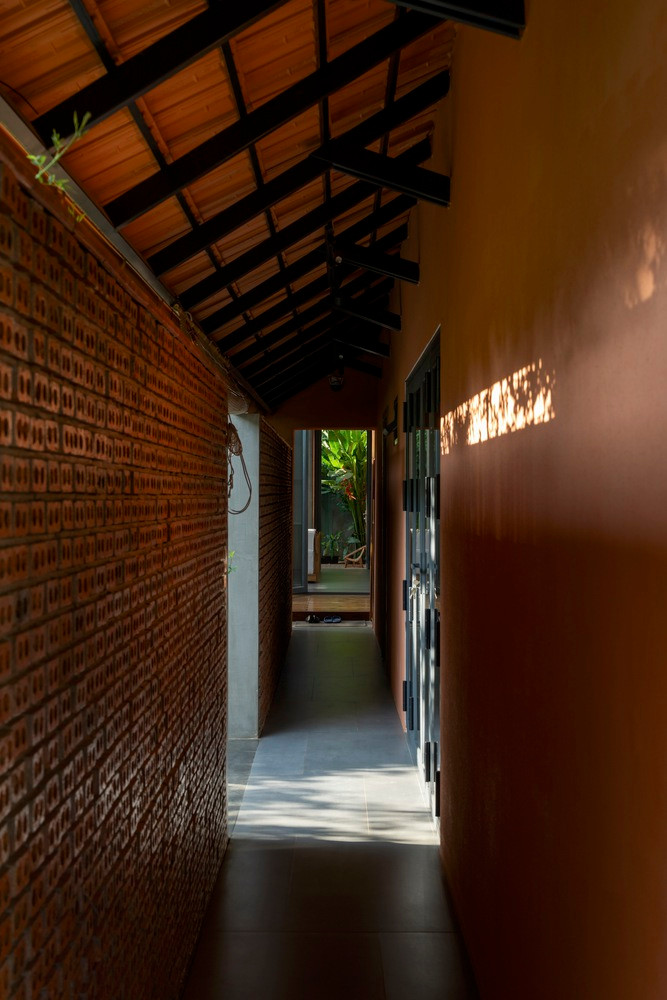 Bức tường gạch thẻ rỗng như những tấm phên chạy dọc công trình tương tự một màn lọc không khí, chắn các tác động xấu cho ngôi nhà. Nguồn ảnh: Quang Trần