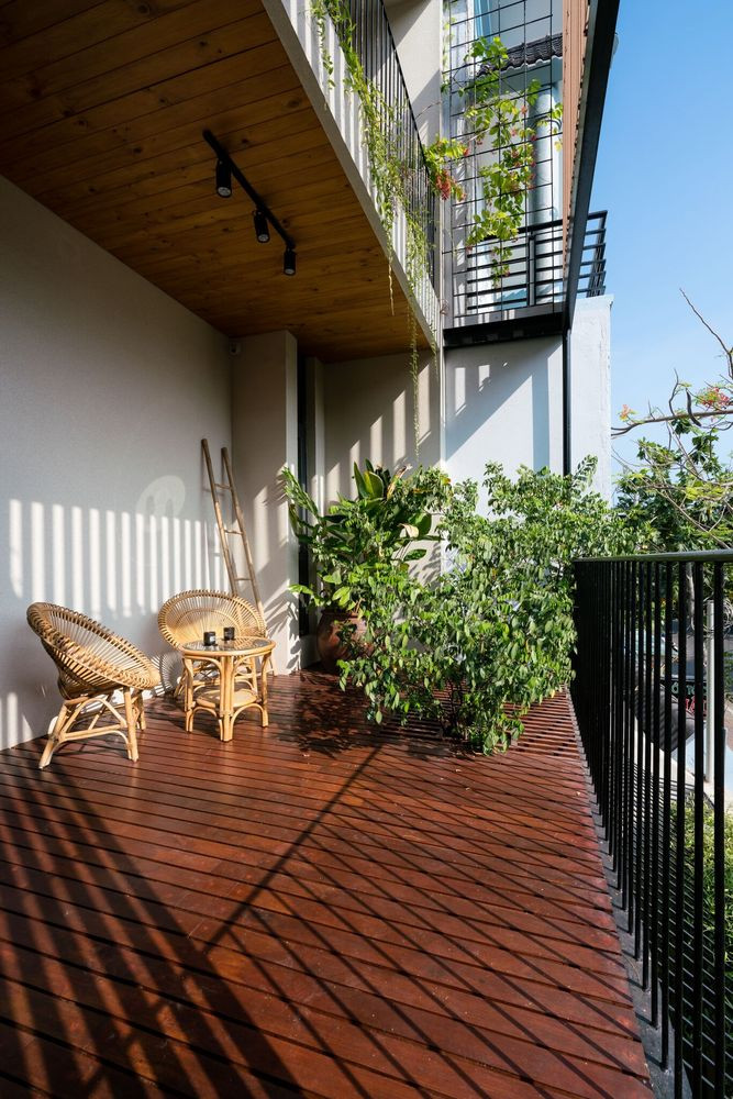 Kiến trúc sư kết hợp bề mặt của hai công trình cũ bằng khung sắt và các trụ gỗ nhựa trong khi mở rộng sân thượng tầng hai trước phòng ngủ chính để tạo không gian thư giãn cho chủ nhà sau một ngày dài. Ảnh: Quang Đàm