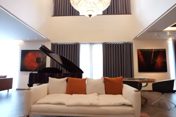 Khu vực tiếp khách có thiết kế thông tầng, sofa êm ái và chiếc đàn piano.