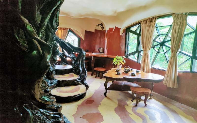 Băng qua những bậc thang ngoằn ngoèo quấn quanh gốc cây là 11 căn phòng mang tên gọi, cách bài trí khác nhau, có những ô cửa sổ lồi lõm hình thù kỳ lạ. Ảnh: vn-kankou.com