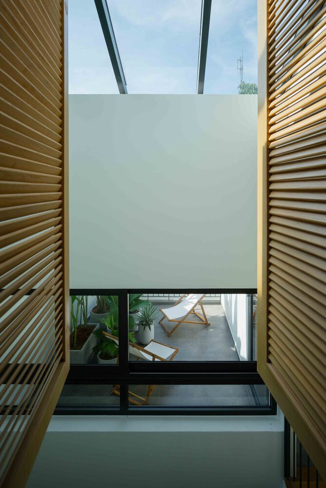 Hệ cửa lá sách gỗ đóng mở linh hoạt, tạo sự riêng tư khi cần thiết và lưu thông gió kể cả khi đóng cửa. Ảnh: Quang Tran