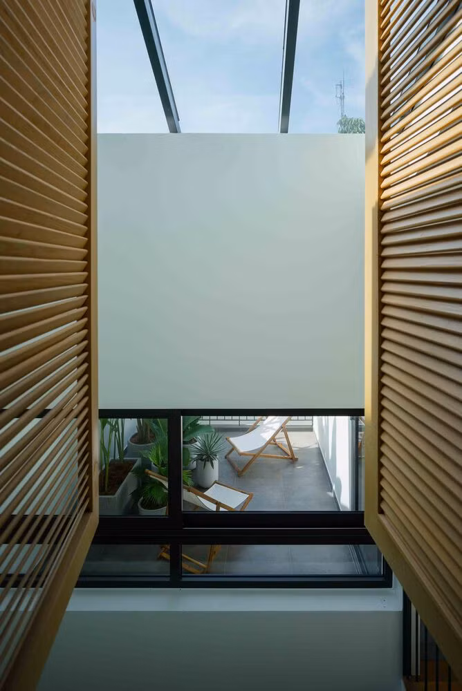 Hệ cửa lá sách gỗ đóng mở linh hoạt, tạo sự riêng tư khi cần thiết và lưu thông gió kể cả khi đóng cửa. Ảnh: Quang Tran