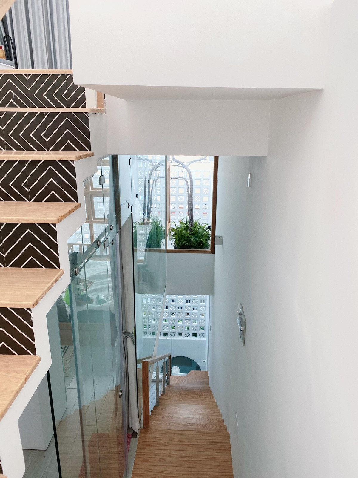 Cầu thang nhỏ gọn thiết kế ngay sau bức tường gạch hoa gió đón sáng cho khu vực di chuyển. Ảnh: T H I A architechture