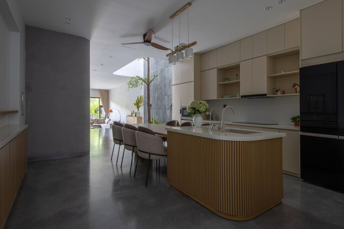 Cạnh giếng trời giữa nhà là không gian bếp tối giản.