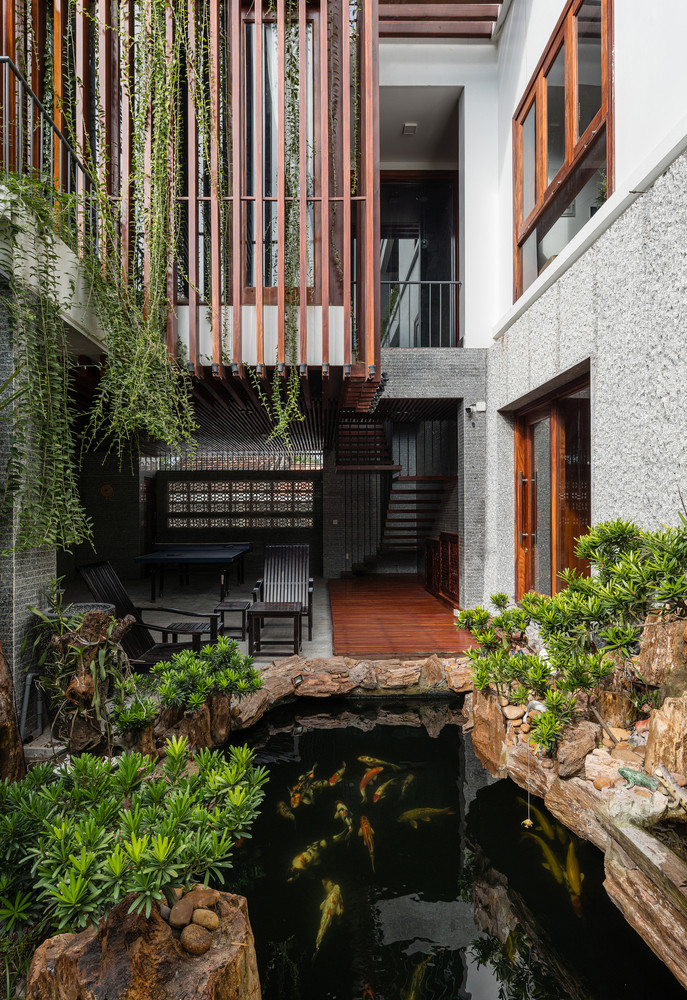 Mặt tiền là những tấm rèm xanh cùng tông màu trầm ấm của gỗ dựa trên kết cấu sẵn có được phân khúc hợp lý, vừa để giảm bức xạ nhiệt vừa mang lại bóng mát và vẻ thơ mộng khi trở về nhà.