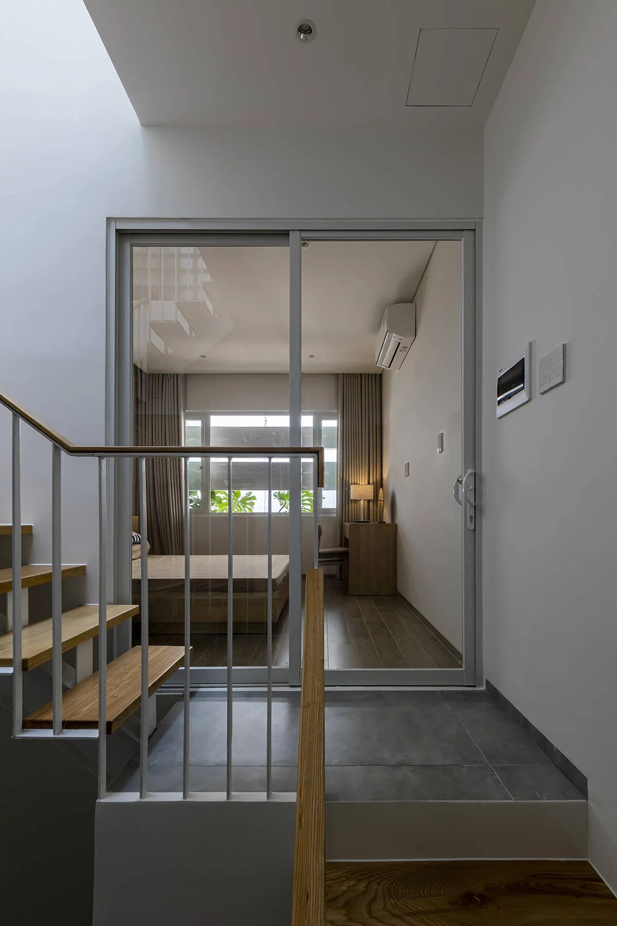 Cầu thang sắt hở bậc góp phần tạo nên các khe sáng tự nhiên.