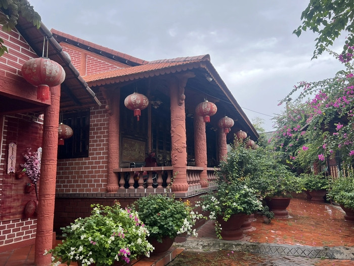 Điểm đặc biệt của căn nhà là 90% làm bằng gốm đỏ. Ông Buôi tự thiết kế bản vẽ, tự tính toán kỹ thuật và phác họa từng chi tiết cho căn nhà. Ảnh: Người lao động