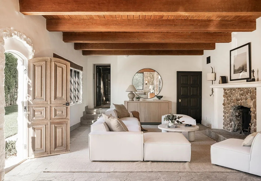 Tầng dưới được tạo điểm nhấn bởi sàn đá, trần nhà bằng xà gỗ và lò sưởi bằng đá.