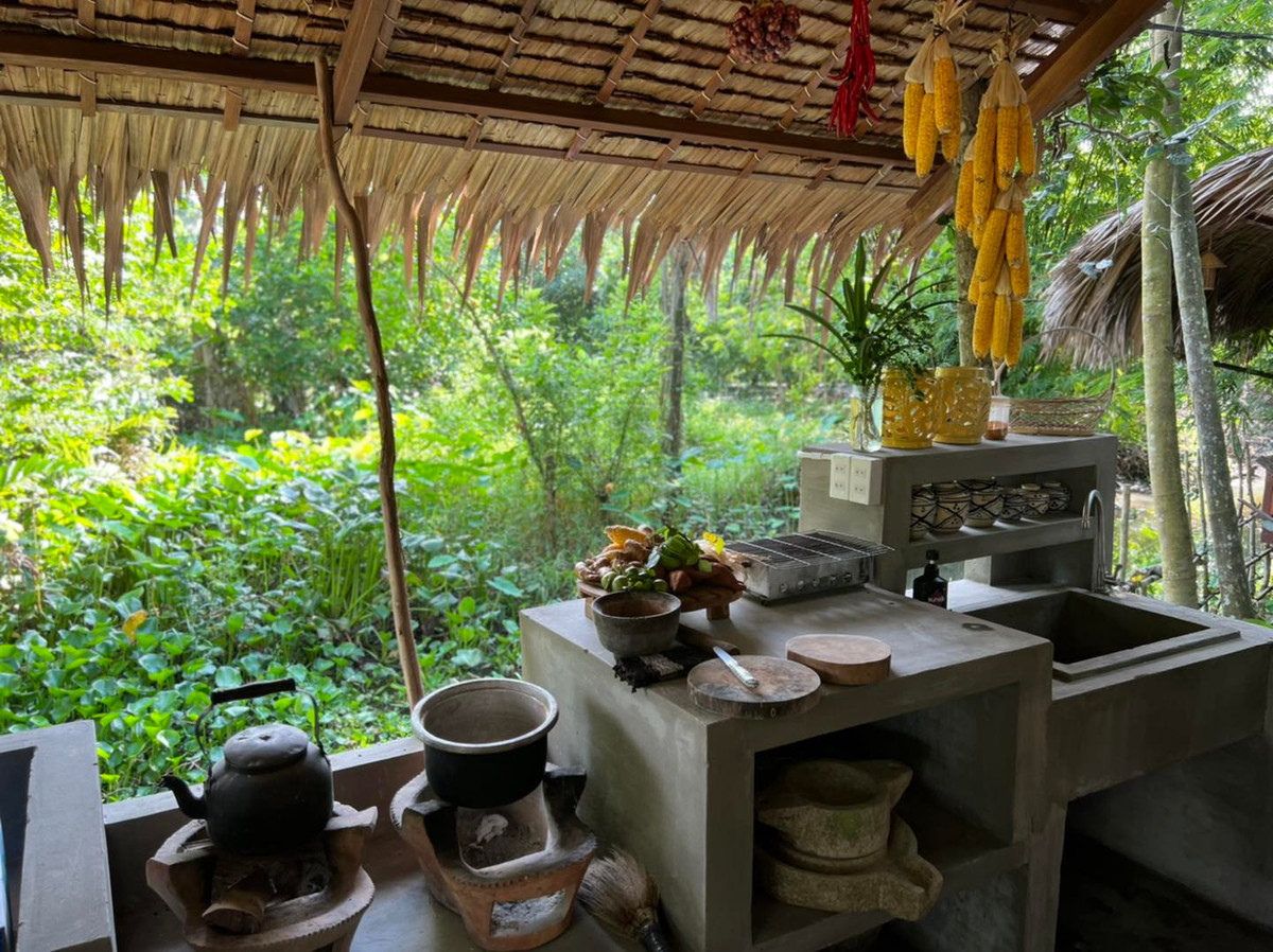 Một khu bếp theo phong cách xưa với ấm, nồi đều nấu bằng lò than.