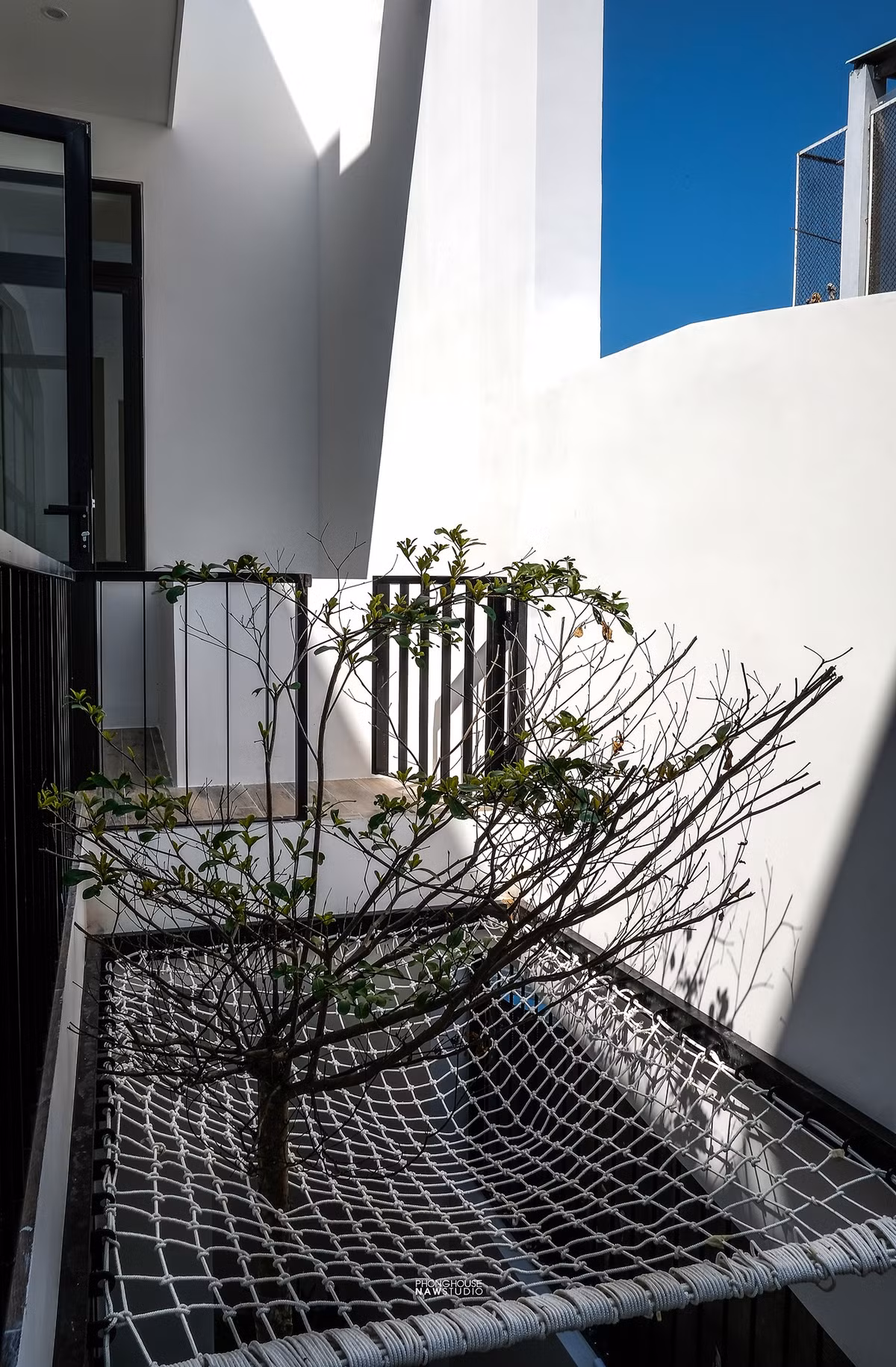 Tại đây được bố trí thêm một chiếc võng lưới để gia chủ thư giãn.