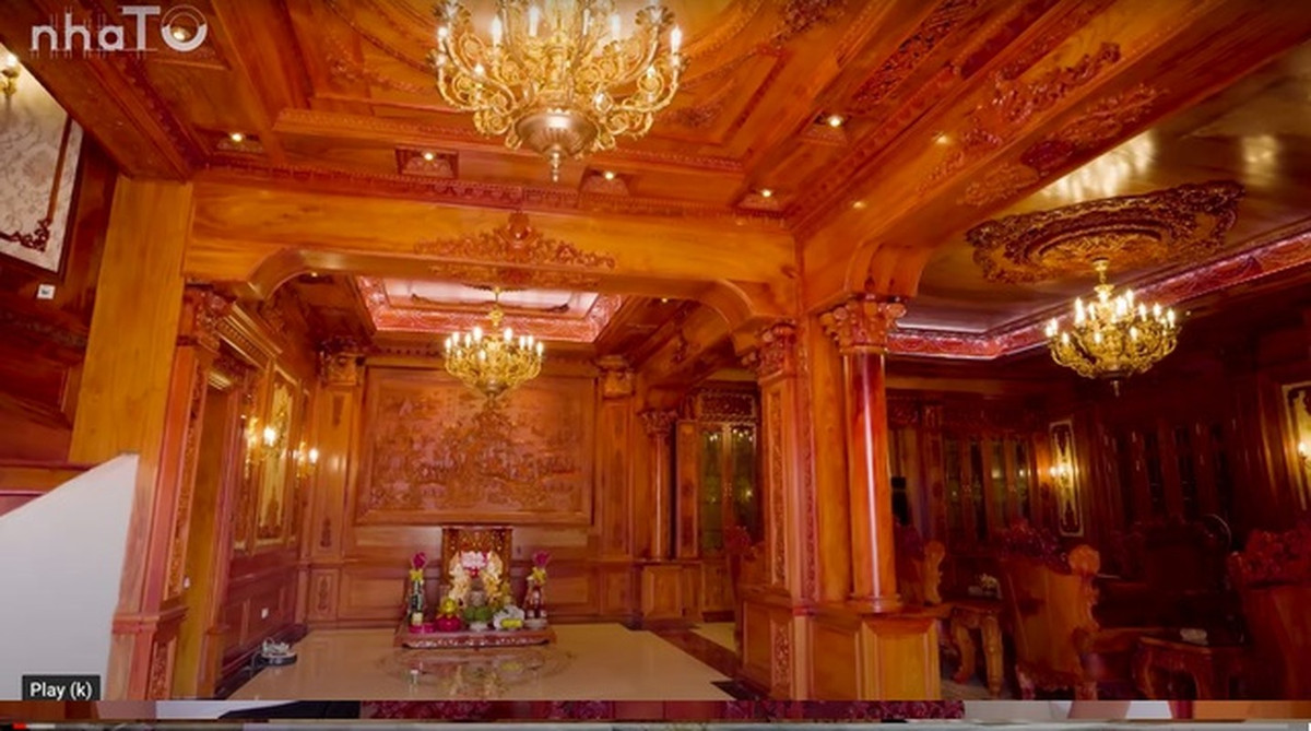 Bước qua cánh cửa là không gian phòng khách rộng tới 80m2, nền lát đá cao cấp, còn trần nhà, tường nhà và các đồ vật xung quanh đều làm toàn bộ từ gỗ đỏ. Ảnh chụp màn hình