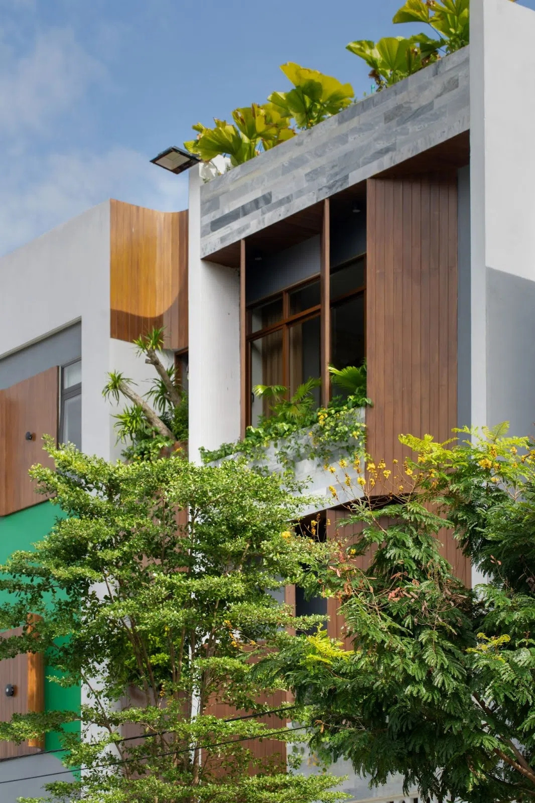 Căn nhà nằm trong khu đô thị, nên nếu không xử lý khéo sẽ bí bách, thiếu khoảng thở và hứng trọn ánh nắng gay gắt vào buổi chiều. Đây cũng là yêu cầu khó của dự án. Ảnh: GreenConcept