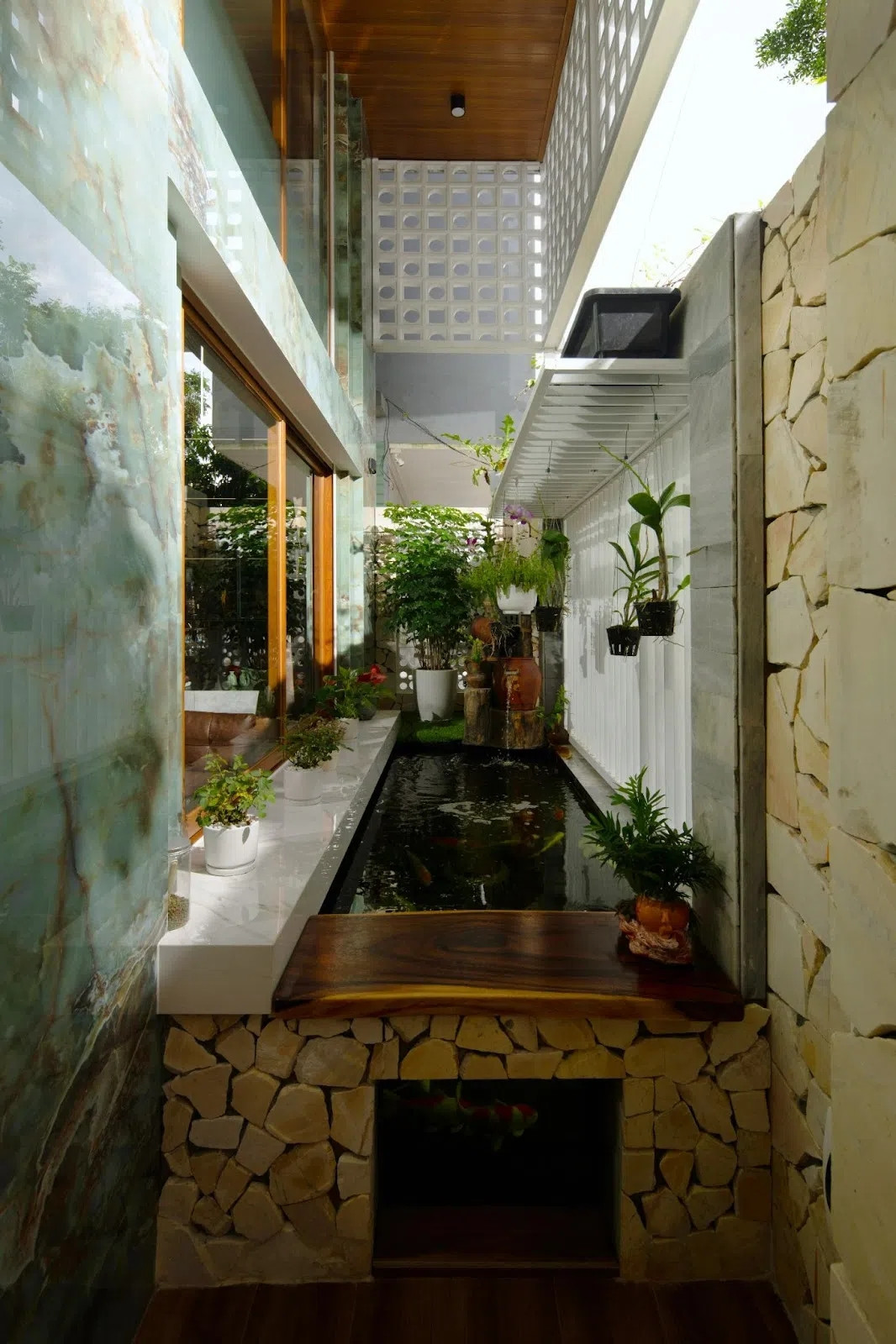 Để giải quyết vấn đề trên, kiến trúc sư chọn giải pháp hồ cá làm lớp đối lưu không khí cũng chính là vùng không gian đệm có chức năng phân cách không gian sống bên trong với môi trường bên ngoài. Ảnh: GreenConcept