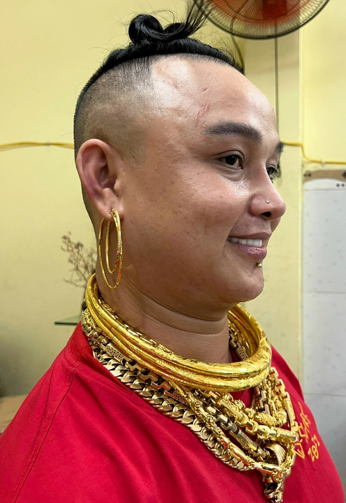 Dù mang 8 chiếc nhẫn to bản phủ đầy hai bàn tay, hai bộ lắc 49 chiếc che kín cánh tay và 8 sợi dây chuyền trên cổ, ông chủ quán không cảm thấy vướng víu khi làm việc. Ảnh: Dân trí