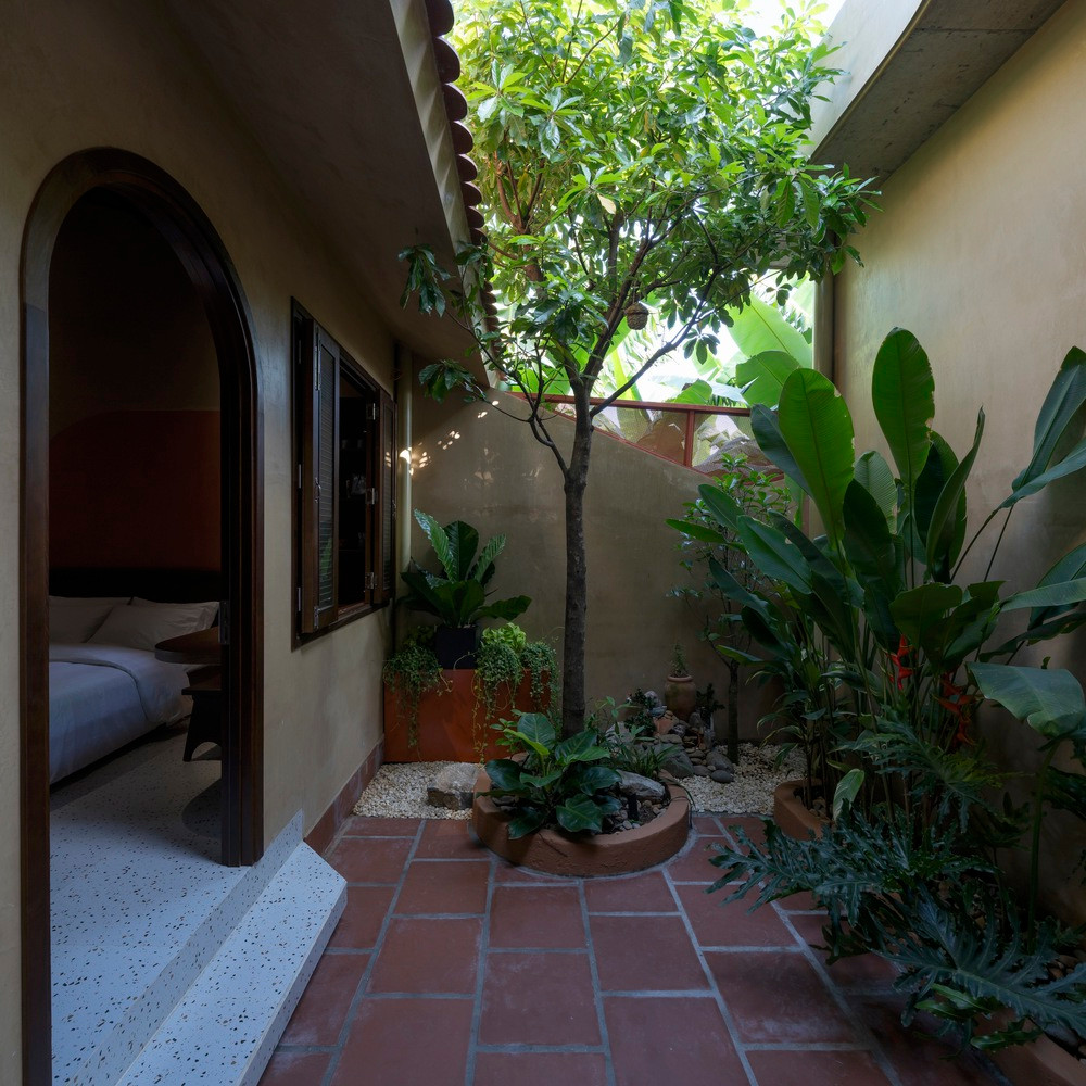 Sân vườn tạo sự riêng tư cho gia chủ, hạn chế tầm nhìn từ phòng khách với các lớp cây xanh, đồng thời giúp phòng ngủ thoáng mát, yên tĩnh hơn.