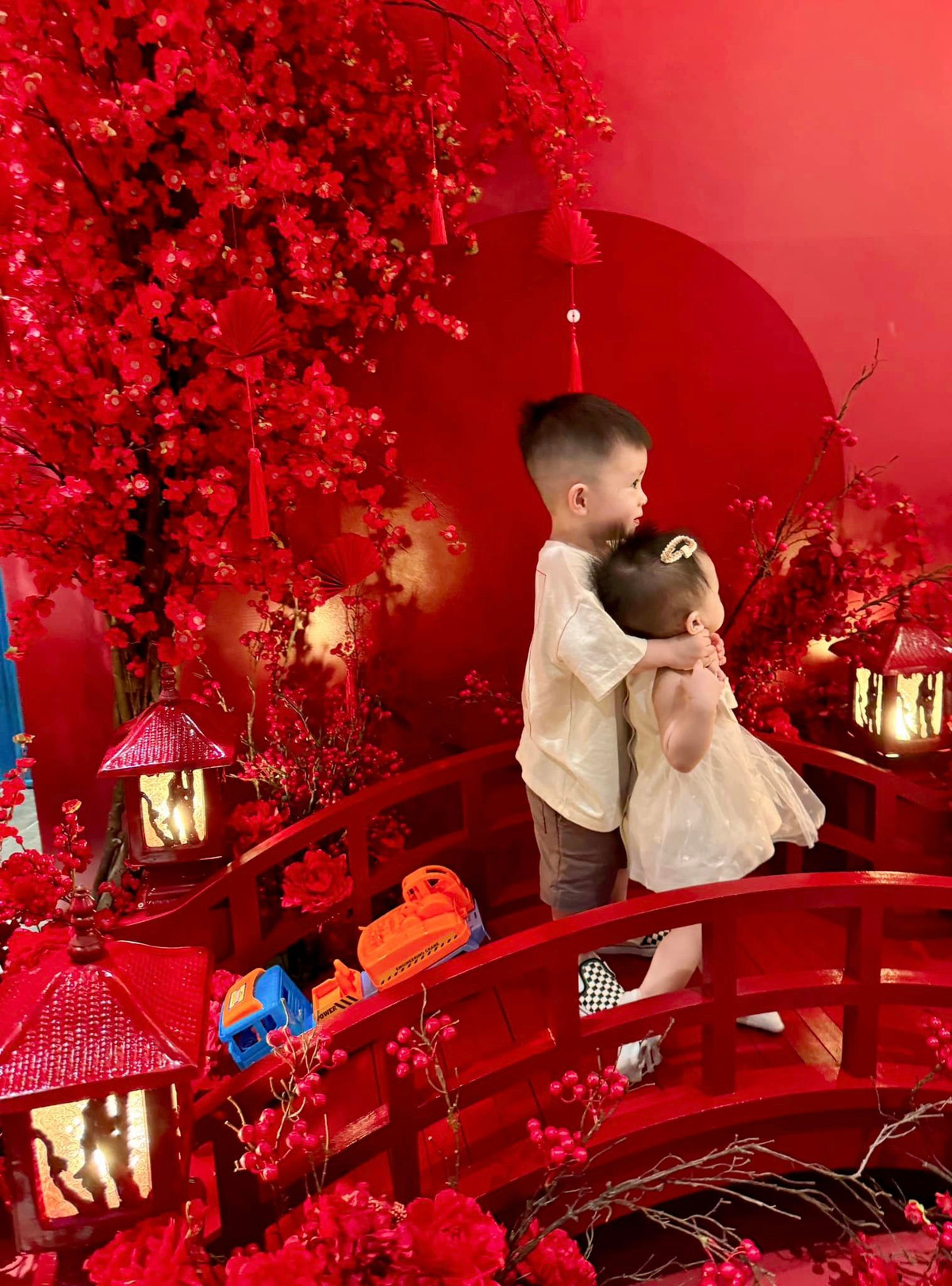 Tại lối dẫn vào phòng khách có một chiếc bục chụp ảnh nhỏ mang tông màu đỏ thuần bắt mắt. Đoàn Di Băng cho người thiết kế thêm mô hình chiếc cầu gỗ và đặt một cây hoa đào bên cạnh để tạo background "sống ảo".