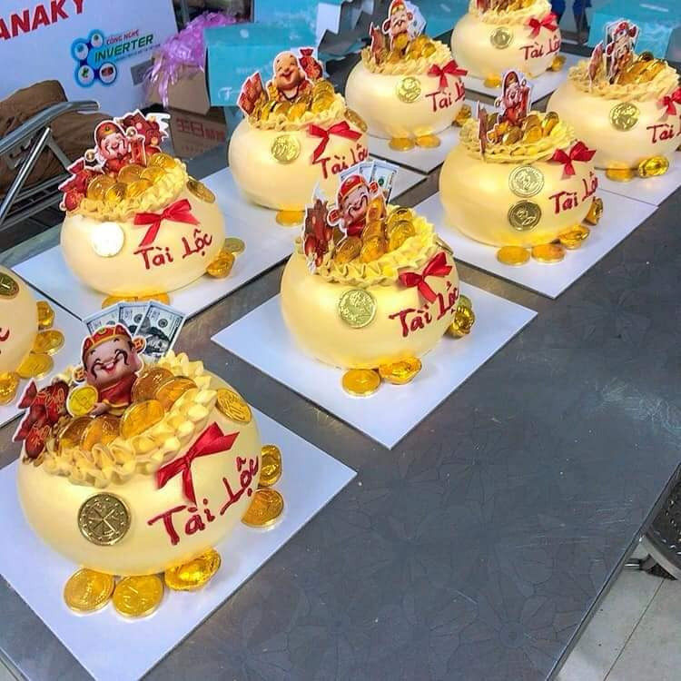 Phần chính của bánh hũ vàng là phần đế bánh kem hình túi tiền căng mọng. Phía trên được trang trí tiền, vàng, tượng thần tài, mèo chiêu tài…rất đẹp mắt.