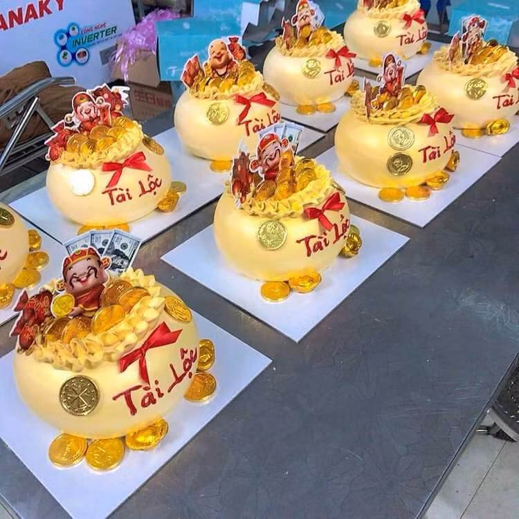 Phần chính của bánh hũ vàng là phần đế bánh kem hình túi tiền căng mọng. Phía trên được trang trí tiền, vàng, tượng thần tài, mèo chiêu tài…rất đẹp mắt.