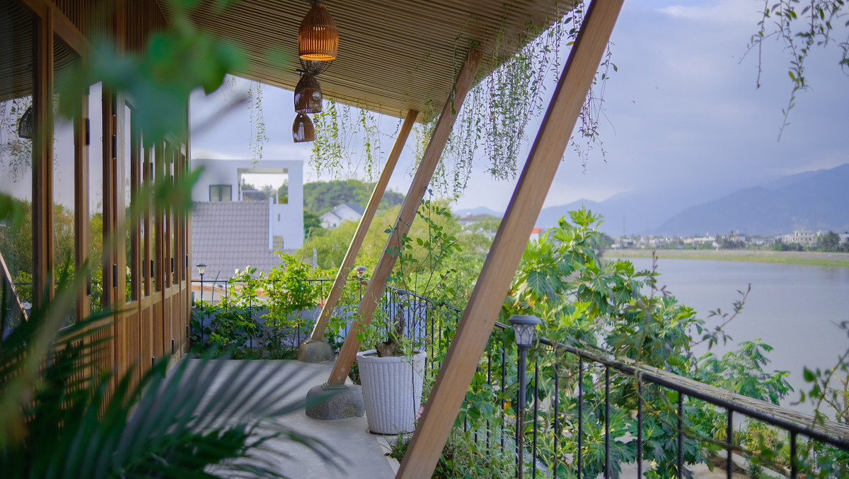 Sân hiên nhìn ra dòng sông thơ mộng, xa xa là thành phố nhấp nhô yên bình trong sương sớm.