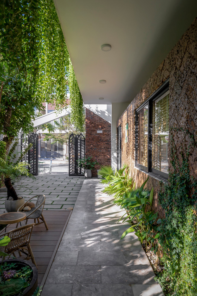 Sân vườn rộng nằm song song với khu vực làm việc và vuông góc với không gian sinh hoạt.