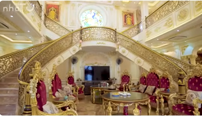 Cầu thang và bộ bàn ghế phòng khách bằng gỗ trắc sơn vàng lấp lánh.