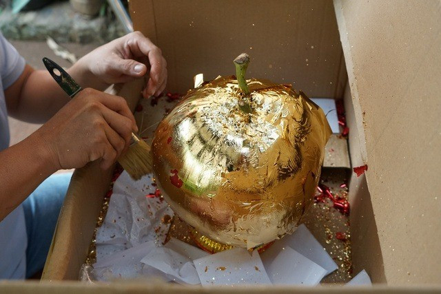 Để trái dừa đẹp hơn, căng bóng, người thợ dùng cọ quét lại một lượt. Đây là công đoạn đòi hỏi người thợ phải thật tỉ mỉ, khéo tay. Ảnh: Người lao động