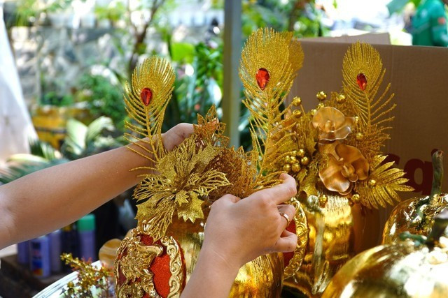 Để làm ra một quả dừa dát vàng, người thợ trải qua nhiều công đoạn. Thông thường mất từ 1 - 2 giờ để cho ra một cặp dừa thành phẩm. Ảnh: Người lao động