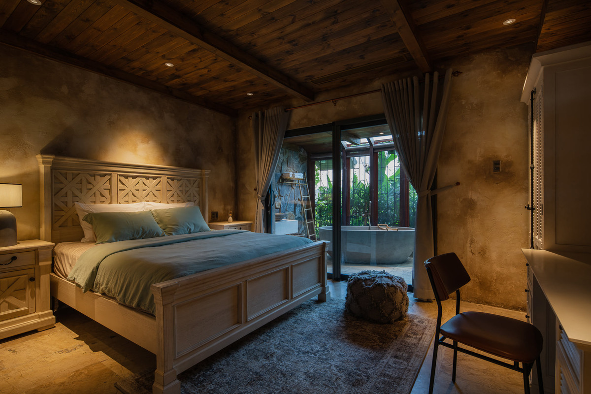 Thiết kế phòng ngủ mang hơi hướng cổ điển, sử dụng cửa trượt mở ra khu vườn xanh mướt. Ảnh: Quang Dam