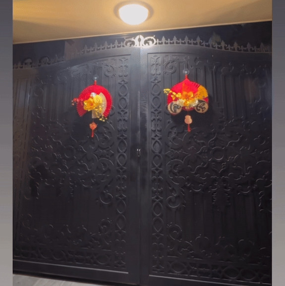 Dịp Tết năm nay, nữ ca sĩ chọn phong cách decor đơn giản và ít màu mè hơn. Tại cổng vào, Lệ Quyên cho treo 2 chiếc quạt phối hoa trước cửa. Trên quạt còn có thêm dòng chữ Phúc - Thọ.