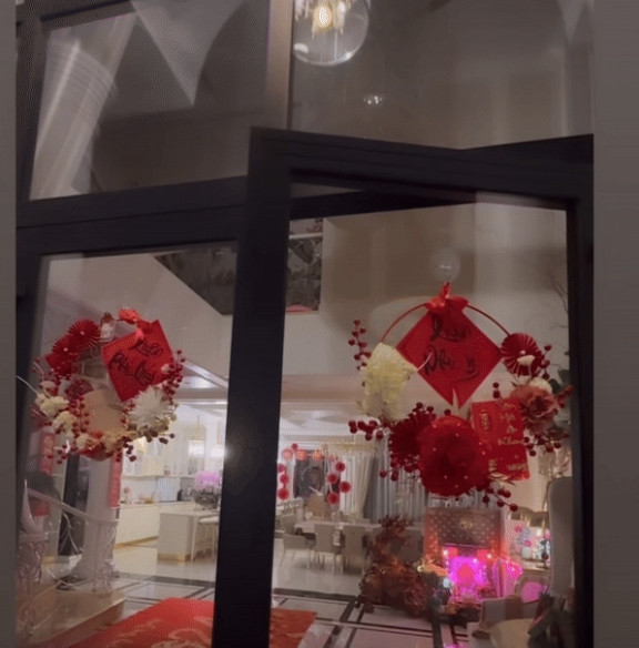 Tại cửa ra vào, Lệ Quyên sử dụng những chiếc vòng hoa để trang hoàng. Mẫu vòng được Tết từ những cành đông đào đỏ, kèm ruy băng và câu đối.