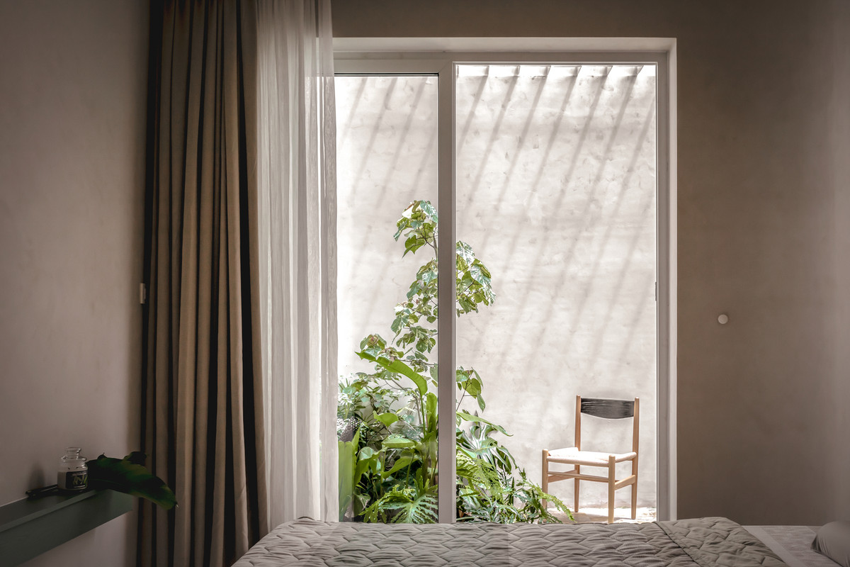 Phòng ngủ master thoáng đãng nhờ khoảng sân vườn phía sau.