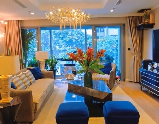 Phòng khách của gia đình Mạnh Trường có điểm nhấn là chiếc đèn chùm lộng lẫy, hài hòa giữa nội thất cao cấp và thiết kế mở. Ảnh: chụp màn hình