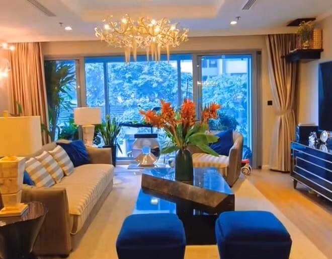 Phòng khách của gia đình Mạnh Trường có điểm nhấn là chiếc đèn chùm lộng lẫy, hài hòa giữa nội thất cao cấp và thiết kế mở. Ảnh: chụp màn hình