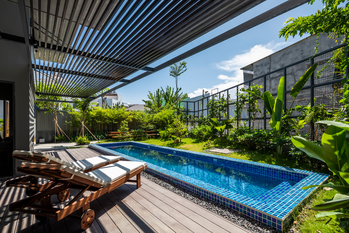 Bể bơi kết hợp khoảng hiên để ghế nằm thư giãn biến căn nhà thành một khu nghỉ dưỡng tại gia của gia đình.